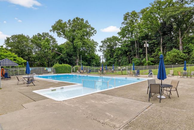 Community pool featuring a patio and view of scattered trees | Image 40