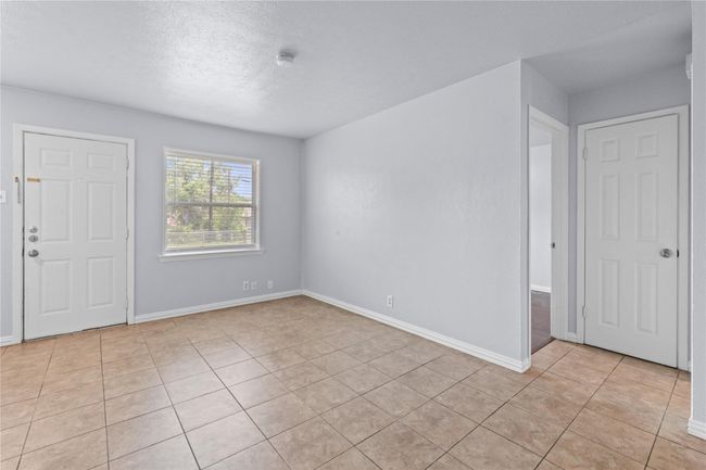 Unfurnished room featuring light tile patterned flooring, a smoke detector, and a textured ceiling | Image 9