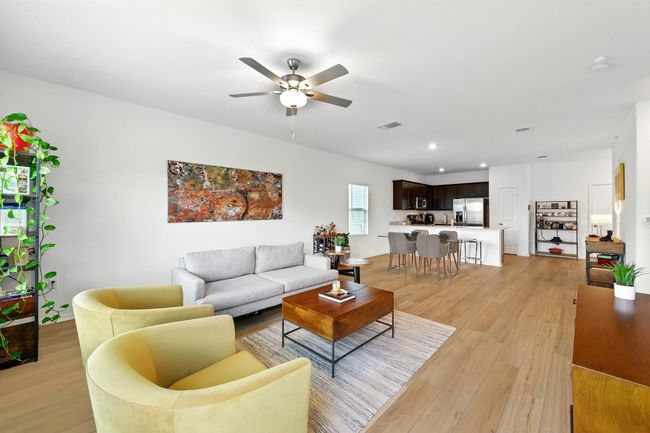 Living room with ceiling fan, light wood finished floors, and recessed lighting | Image 5