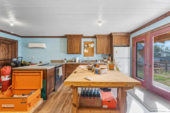 Kitchen with white refrigerator, light hardwood / wood-style floors, stainless steel range with electric cooktop, and a wealth of natural light | Image 53