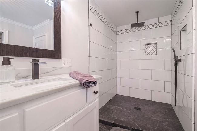 Bathroom with vanity, tiled shower, and crown molding | Image 14