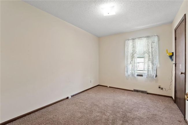 Carpeted empty room with a textured ceiling and baseboards | Image 16