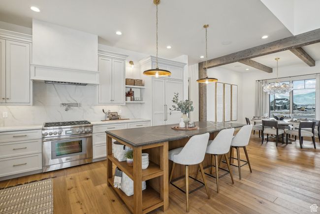Kitchen with a kitchen island, stainless steel range, and white cabinets | Image 11