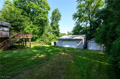 View of yard featuring a garage, an outbuilding, and a deck | Image 3