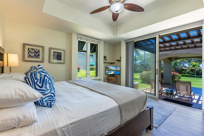 The garden-view primary bedroom opens seamlessly to the large lanai area & is filled with natural | Image 13