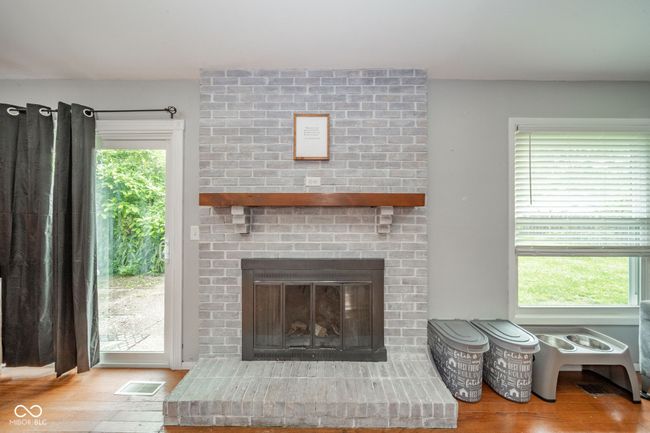 living room featuring wood finished floors and a brick fireplace | Image 12