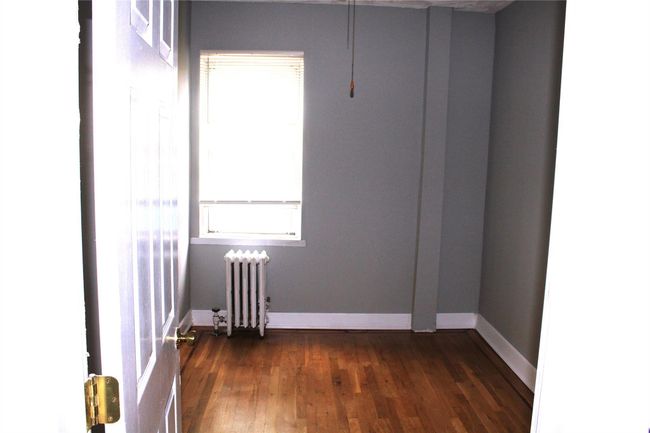 Empty room featuring radiator, dark wood-style floors, and baseboards | Image 15