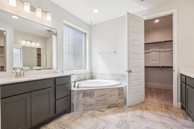 Dual vanities, a soaking tub, oversized shower, and TWO generous walk-in closets complete this luxurious primary bath | Image 24