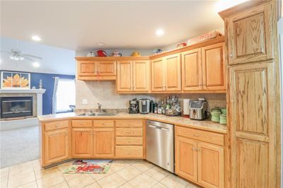 Kitchen features tile flooring and stainless steel dishwasher, and sink | Image 3