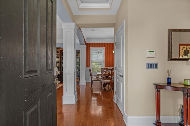Entrance foyer with ornate columns, crown molding, and wood finished floors | Image 8