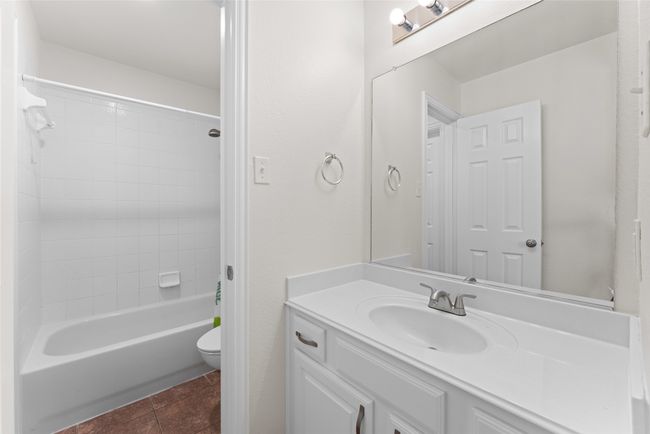 Full bath featuring vanity, washtub / shower combination, and tile patterned floors | Image 31