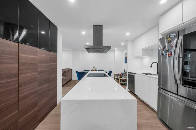 Kitchen featuring a center island, modern cabinets, island range hood, and appliances with stainless steel finishes | Image 9