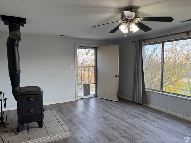 Unfurnished living room featuring wood finished floors, ceiling fan, and baseboards | Image 6