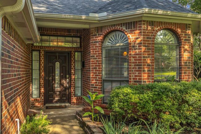 View of exterior entry featuring roof with shingles and brick siding | Image 5