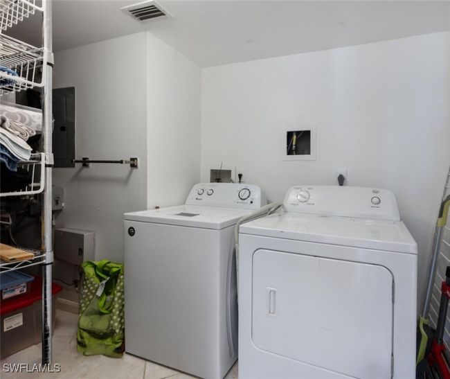Laundry area featuring washing machine and clothes dryer, visible vents, laundry area, and electric panel | Image 16