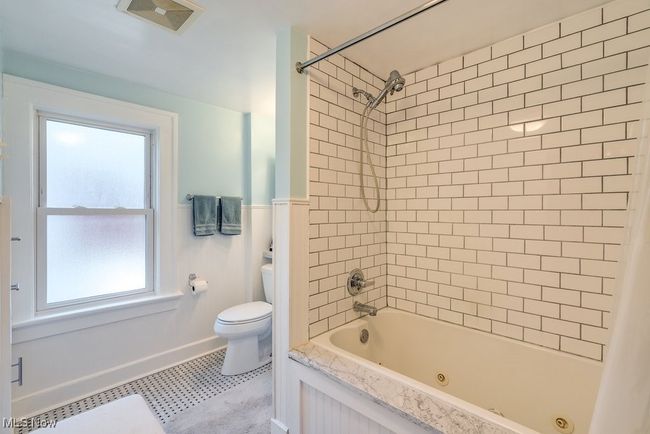 Full bathroom featuring toilet, a healthy amount of sunlight, tile patterned floors and marble | Image 18
