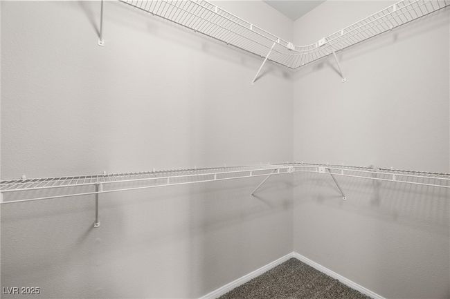 Walk in closet featuring dark carpet | Image 26