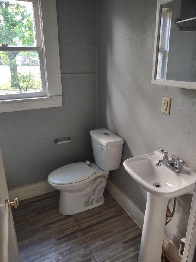 Bathroom with toilet, baseboards, wood finished floors, and a sink | Image 32