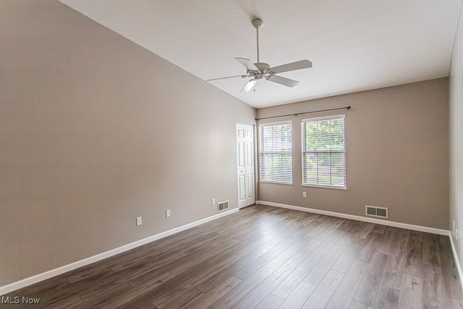 Empty room with lofted ceiling, dark wood-type flooring, and ceiling fan | Image 32