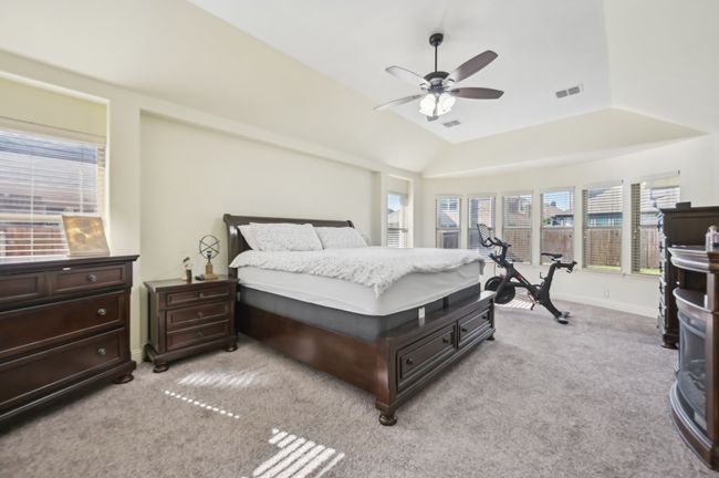 Bedroom with visible vents, baseboards, light colored carpet, and vaulted ceiling | Image 21