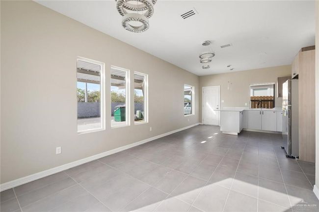 Unfurnished living room with light tile patterned floors, baseboards, and a sink | Image 17
