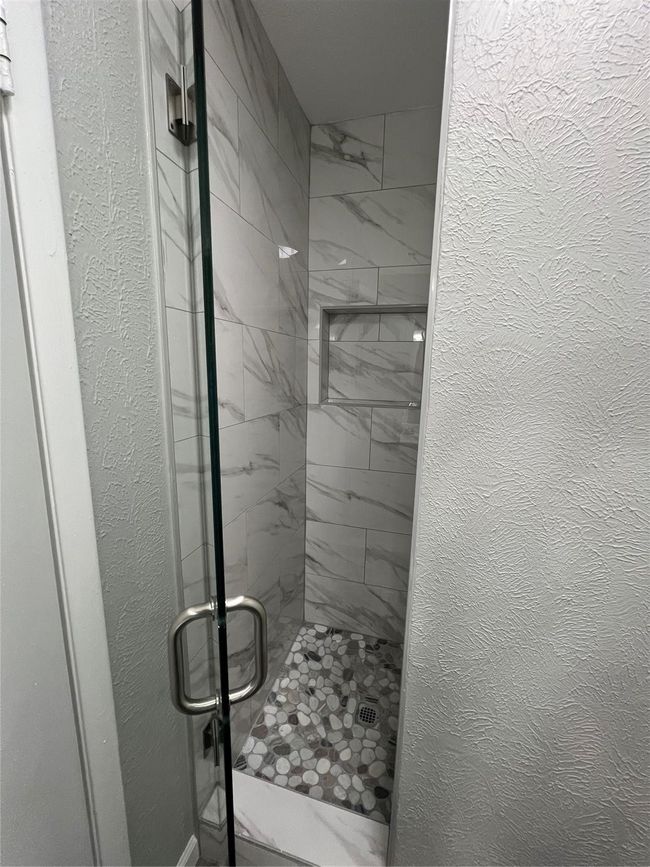 Full bath featuring a stall shower and a textured wall | Image 14