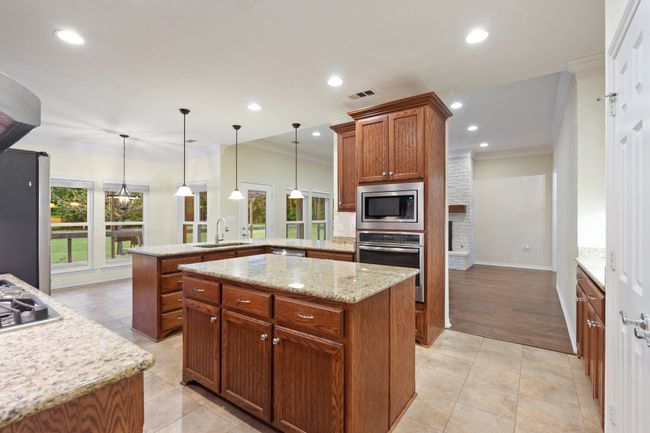 Kitchen featuring a peninsula, crown molding, visible vents, stainless steel appliances, and a sink | Image 6
