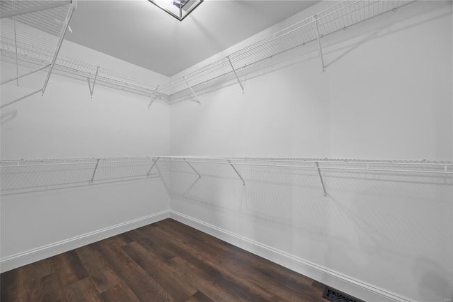 Spacious closet with dark wood-style floors | Image 41
