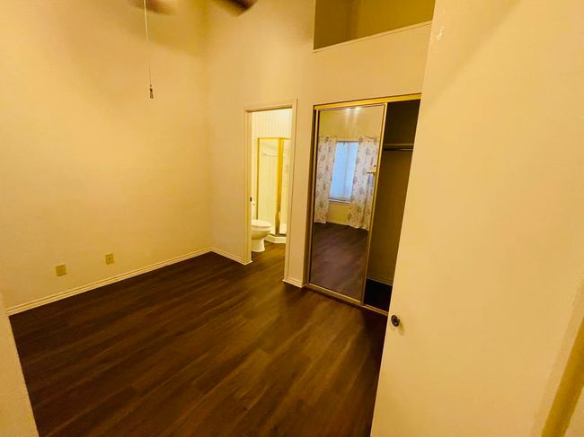 Unfurnished room with dark wood-style floors, a ceiling fan, and a high ceiling | Image 8