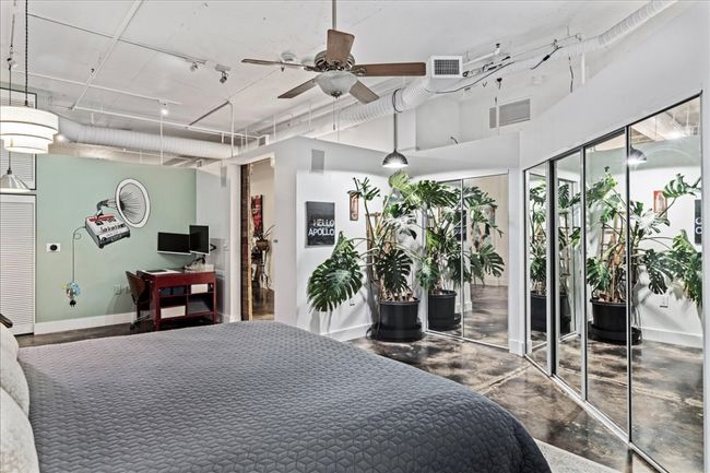 Bedroom with multiple closets, finished concrete flooring, and rail lighting | Image 21