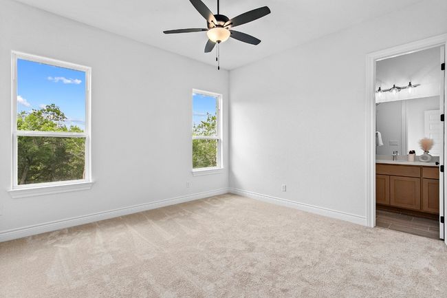 Bedroom 2- Unfurnished bedroom featuring light carpet, connected bathroom, and ceiling fan | Image 24