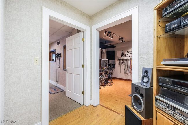 Hall featuring visible vents, baseboards, light wood-style flooring, a drop ceiling, and track lighting | Image 10