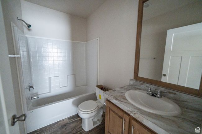Bathroom with wood finished floors, toilet, vanity, and bathtub / shower combination | Image 63