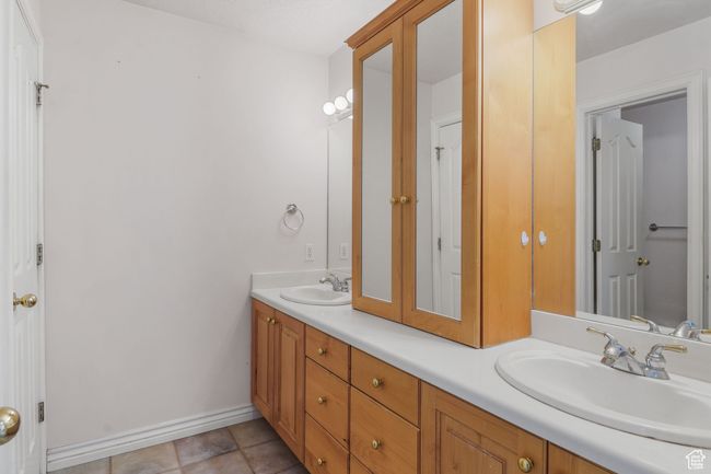 Full bathroom featuring double vanity, baseboards, tile patterned flooring, and a sink | Image 21