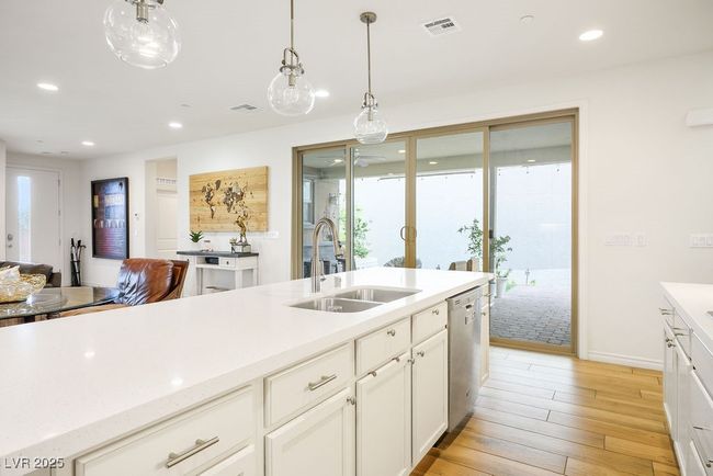 Kitchen with a sink, visible vents, dishwasher, light wood finished floors, and recessed lighting | Image 18