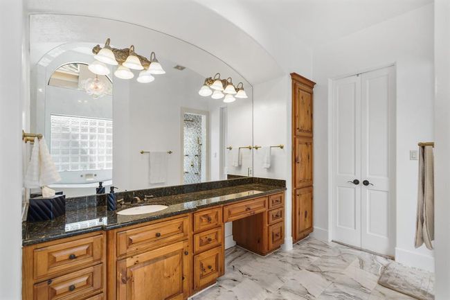 Included is a make-up vanity area, built-in linen storage closet, a private water closet & tile floors. | Image 22
