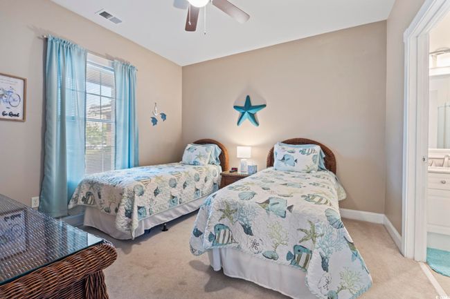 Carpeted bedroom with a ceiling fan and connected bathroom | Image 10
