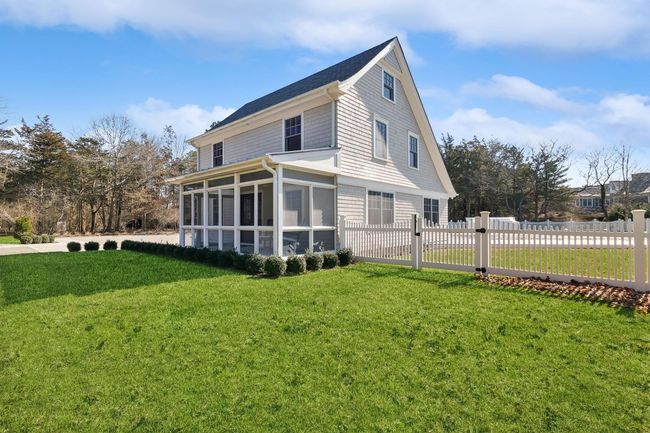 Rear view of house with a sunroom and a yard | Image 4