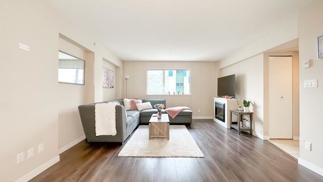 Living area with baseboards, a glass covered fireplace, and dark wood-style floors | Image 4