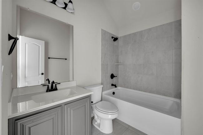Upstairs full bathroom with vanity, tile patterned flooring, tiled shower / bath combo, and toilet | Image 35