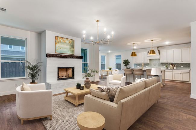 Living room featuring a chandelier, dark wood-style floors, baseboards, a fireplace, and healthy amount of natural light | Image 5