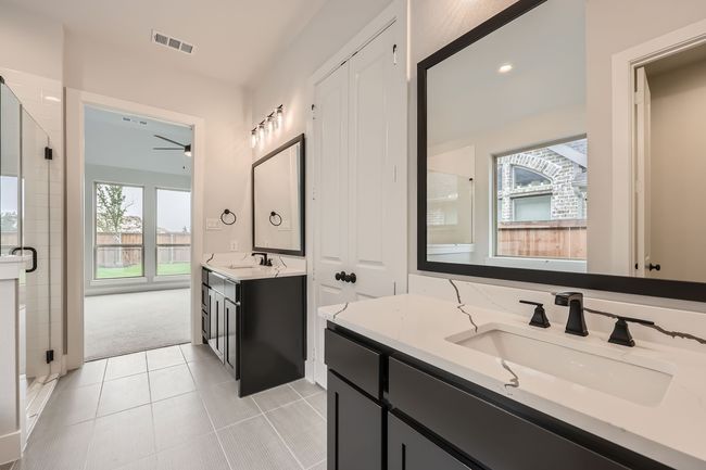 Bathroom with tile patterned flooring, a sink, a shower stall, and visible vents | Image 17