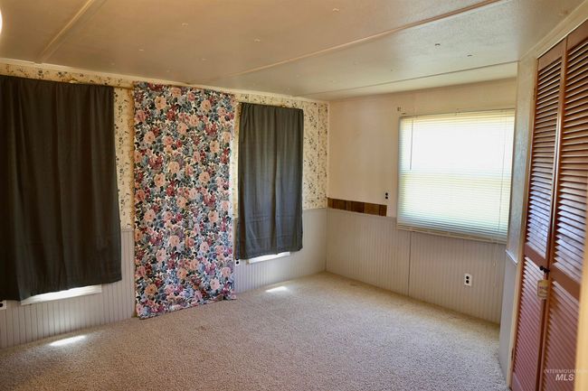 Carpeted empty room featuring wallpapered walls and wainscoting | Image 11