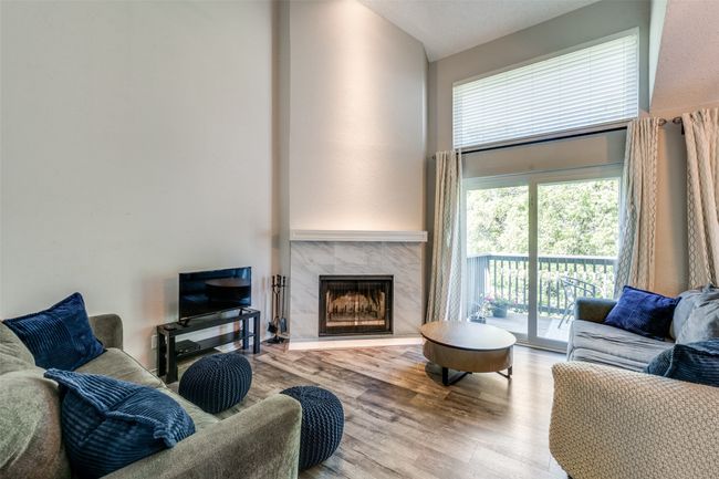 Living room with a high end fireplace, high vaulted ceiling, and wood finished floors | Image 15