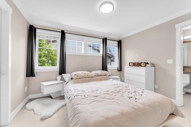 Bedroom featuring light colored carpet, crown molding, and ensuite bathroom | Image 17