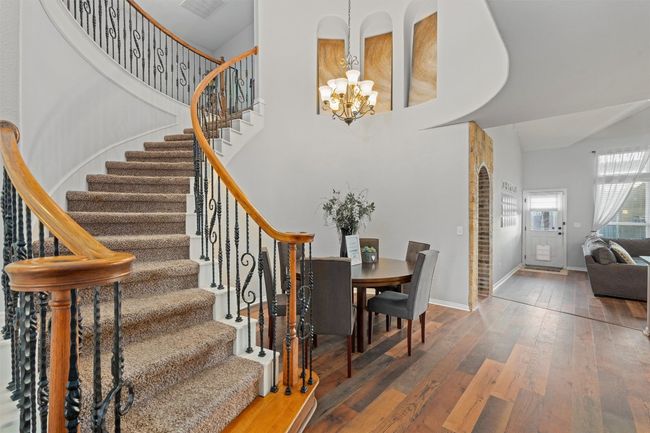 Stairs featuring a chandelier, wood-type flooring, and a high ceiling | Image 4