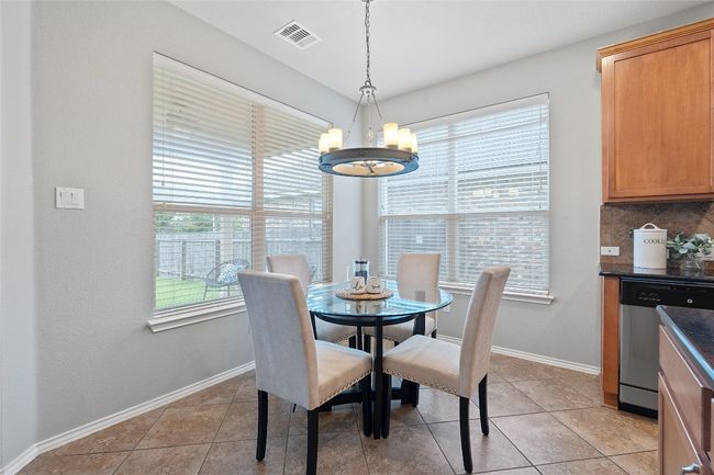 Dining space featuring a chandelier, plenty of natural light, and light tile patterned floors | Image 19
