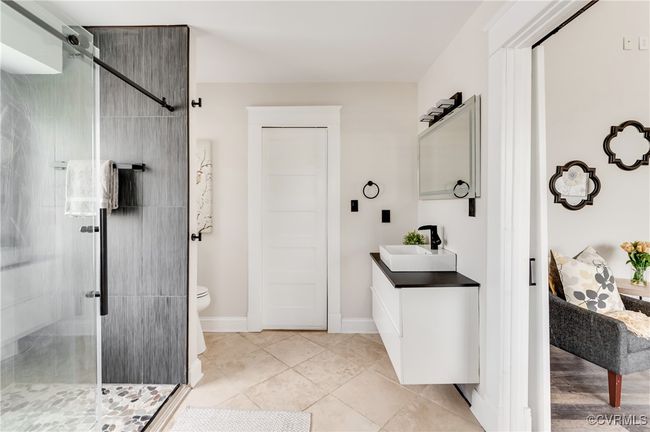 Bathroom featuring toilet, a stall shower, tile patterned floors, and vanity | Image 43