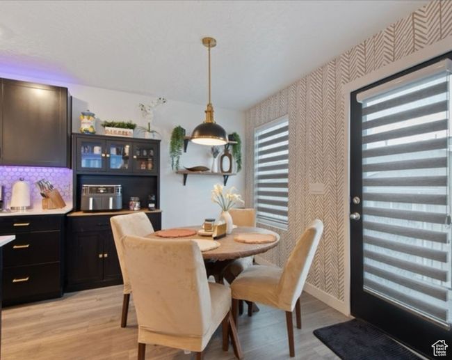 Dining area with wallpapered walls, light wood-style flooring, and baseboards | Image 8