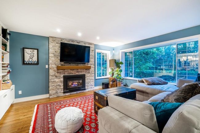 Living room featuring wood finished floors, a stone fireplace, and recessed lighting | Image 11